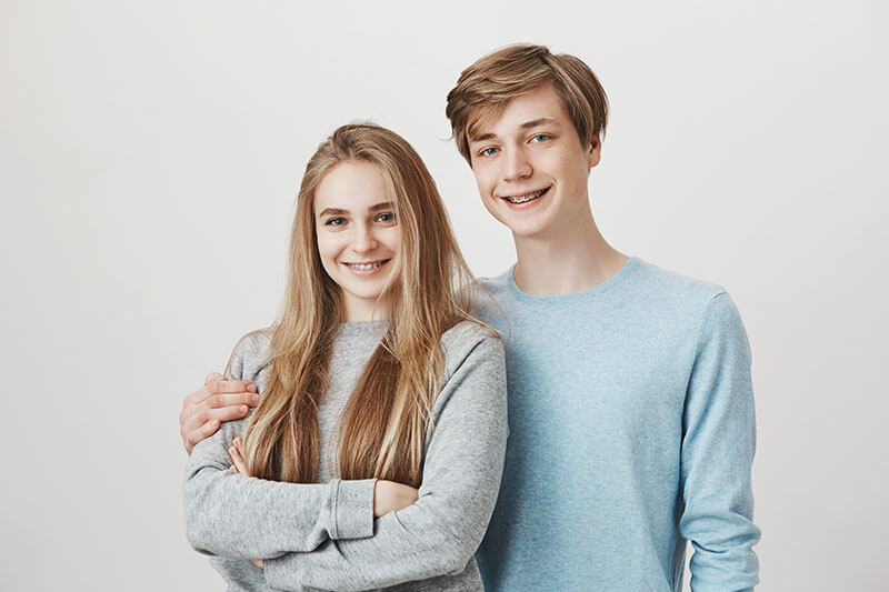 Two teens showing their smiles off.