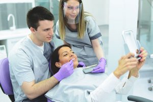 Dental professionals showing their patient their new smile.